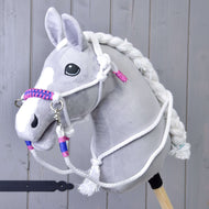 The Rope set White (size M) by Hobby Horse LarDen features a plush gray hobby horse with a white mane, reins, and a braided halter with pink and blue accents, displayed against a wooden background.