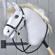 Hobby Horse - Wodze czarne od Hobby Horse LarDen przedstawiają pluszową szarą głowę z czarnym ogłowiem, wodzami z paracordu i białą grzywą na drewnianym kiju, pokazane przed szarymi drewnianymi panelami z widocznym czarnym metalowym zawiasem.