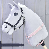 The Hobby Horse LarDen "Breastgirth with fur Mullbery" is shown: a gray plush hobby horse with white mane, black bridle, pink halter, and soft fur breastgirth on a wooden stick, set against a light gray wood background.