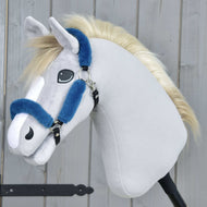 Hobby Horse LarDen Kantar futrzany Teddy Petrol na pluszowym Hobby Horse z jasnoszarej tkaniny, z białym pyskiem, blond grzywą i niebieskim kantarem ze skóry ekologicznej na czarnym kijku, na tle drewna.