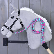 Hobby Horse - Dziana lonża Pinkie-Blue od Hobby Horse LarDen, z szarym pluszowym korpusem, czarną uzdą, białą grzywą i plecioną różowo-turkusową lonżą, zawieszony na drewnianej ścianie. Uchwyt kija w zestawie.