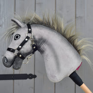 Hobby Horse Prestige z czarnym kantarem, rozmiar XS od Hobby Horse LarDen to pluszowa szara głowa Hobby Horse inspirowana elegancją angielskiego konia gorącokrwistego sportowego. Ma wyrazisty haftowany pysk, rozwianą grzywę i solidny czarny kantar, osadzone na drewnianym kiju. Ujęty na drewnianym tle, idealny jako element pomysłowych przygód w skokach przez przeszkody.