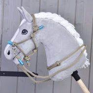 A plush gray Hobby Horse LarDen head with a white mane and Rope set Nature Blue halter is mounted on a wooden stick, positioned against a gray wooden panel background.