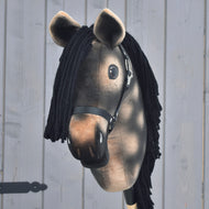 Hobby Horse Stormy z czarnym kantarem od Hobby Horse LarDen, realistyczny dereszowaty hanowerski ogier z czarną włóczkową grzywą i brązową pluszową głową osadzoną na kiju, pokazany na tle jasnoszarej drewnianej ściany.