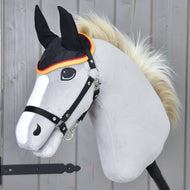 Hobby Horse LarDen Nauszniki Flaga DE na realistycznym szarym Hobby Horse z białą strzałką, czarną uzdą, puszystą białą grzywą i czarnymi uszami z nausznikami chroniącymi przed owadami, osadzonym na kiju na tle drewna.