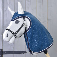 Hobby Horse LarDen „Raincoat Derby” to biały pluszowy Hobby Horse z czarnym kantarem i błyszczącym niebieskim płaszczem przeciwdeszczowym ozdobionym kroplami wody, pokazany na tle jasnych drewnianych desek.
