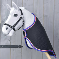 Szara zabawka Hobby Horse z czarnym ogłowiem ma Hobby Horse LarDen Derkę podróżną Luxury — pikowaną, czarną, wykończoną na czerwono, biało i niebiesko — ustawioną na tle drewnianej ściany.