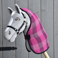 Szary Hobby Horse od Hobby Horse LarDen, z czarną uzdą i derką Derka Stajenna Różowa, jest osadzony na drewnianym kiju i pokazany na tle szarej drewnianej ściany.