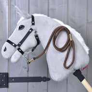 Hobby Horse - sznurkowy pasek Vivaldi Hobby Horse LarDen zawieszony na drewnianym ściennym uchwycie na tle szarego drewna.