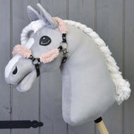 Hobby Horse LarDen Czarny kantar z pełnym futerkiem Old Rose - skóra ekologiczna na pluszowym Hobby Horse z jasnoszarą głową, białą plecioną grzywą i czarnym kantarem, osadzonym na drewnianym kiju na tle drewnianych paneli.