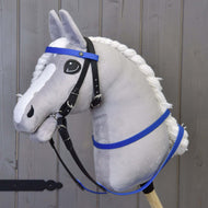 Pluszowy Hobby Horse od Hobby Horse LarDen z szarą głową, białą grzywą i niebieskimi gumowanymi wodzami, osadzony na drewnianym kiju i ustawiony na tle drewnianych paneli.