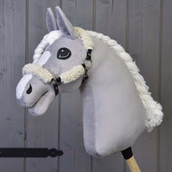 Hobby Horse LarDen przedstawia pluszowego szarego Hobby Horse z czarnym kantarem z pełnym futerkiem i elementami ze skóry ekologicznej, osadzonego na drewnianym kiju na tle drewnianych desek.