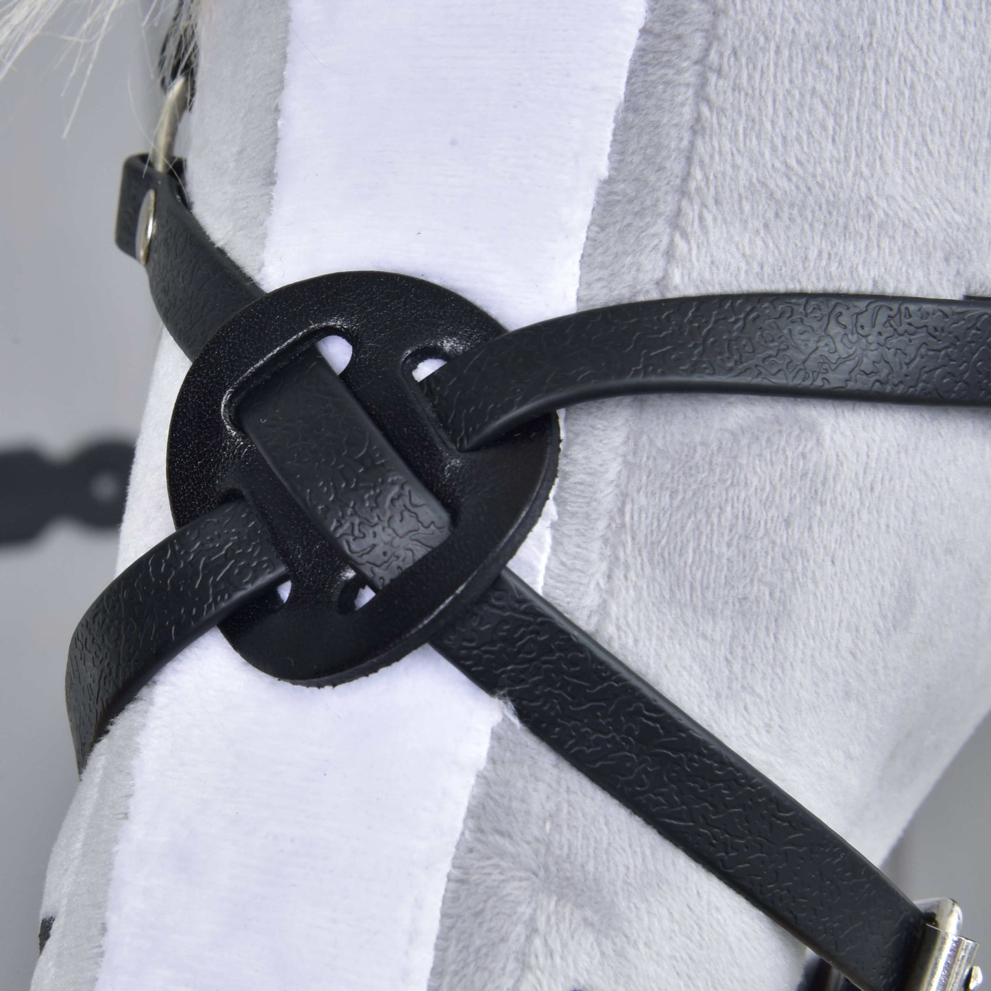 Close-up of the Noseband Mexico Black by Hobby Horse LarDen, featuring a decorative knot in black leatherette, displayed on a white plush surface—possibly part of a harness or bridle for hobby horses.