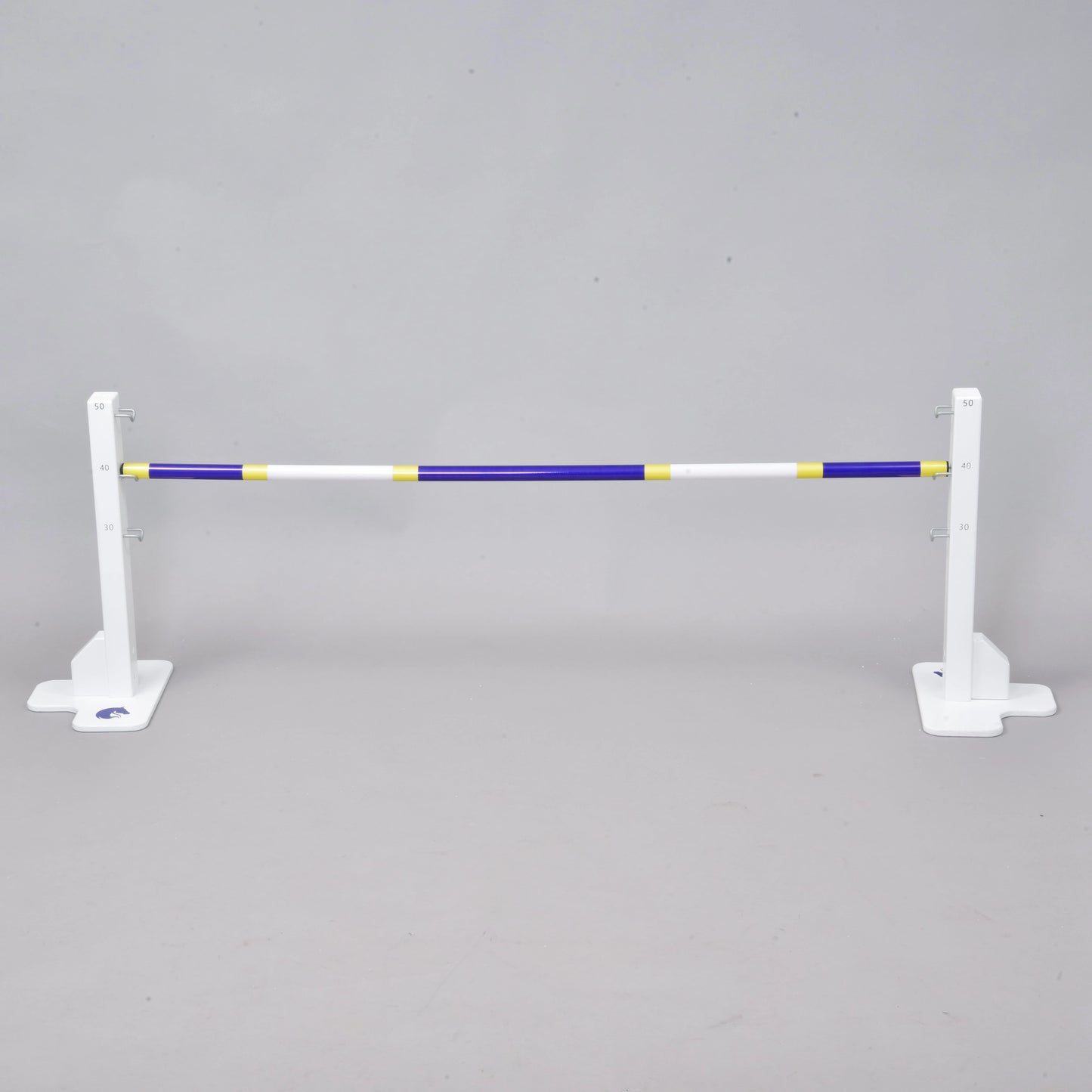 The Hobby Horse LarDen Jump 50 cm / 20 inch is a white adjustable jump stand with a blue, yellow, and white pole—ideal for indoor or outdoor hobby horsing—shown against a plain gray background.