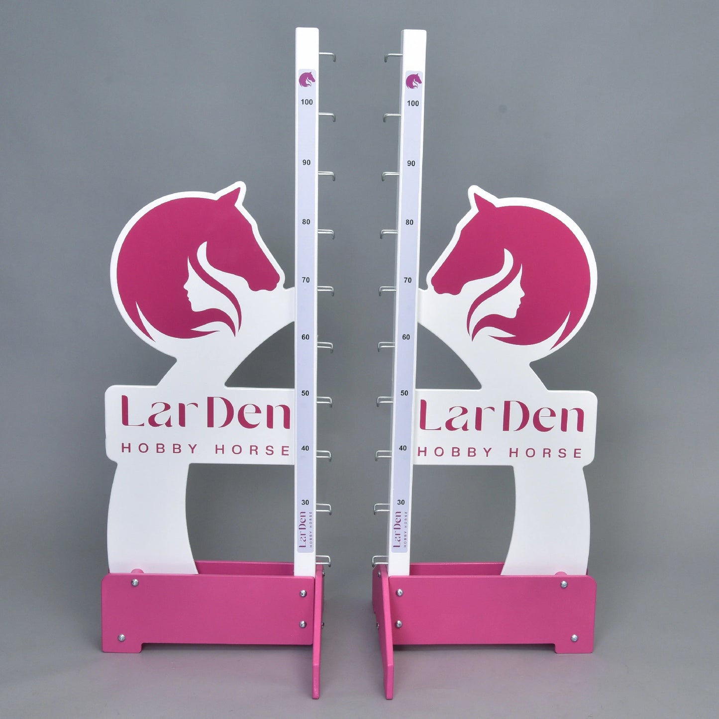 Two LarDen jump 110 cm / 43 inch white and pink stands from Hobby Horse LarDen, with adjustable height up to 110 cm, horse head graphics, and brand text on the base—perfect for hobby horse riding, shown on a plain gray background.