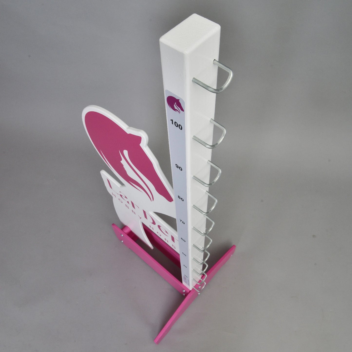 The Hobby Horse LarDen jump 110 cm (43 inch) is a vertical white and pink measuring stand with metal hooks for adjustable height, featuring markings up to 110 cm. Perfect for hobby horse riding enthusiasts.