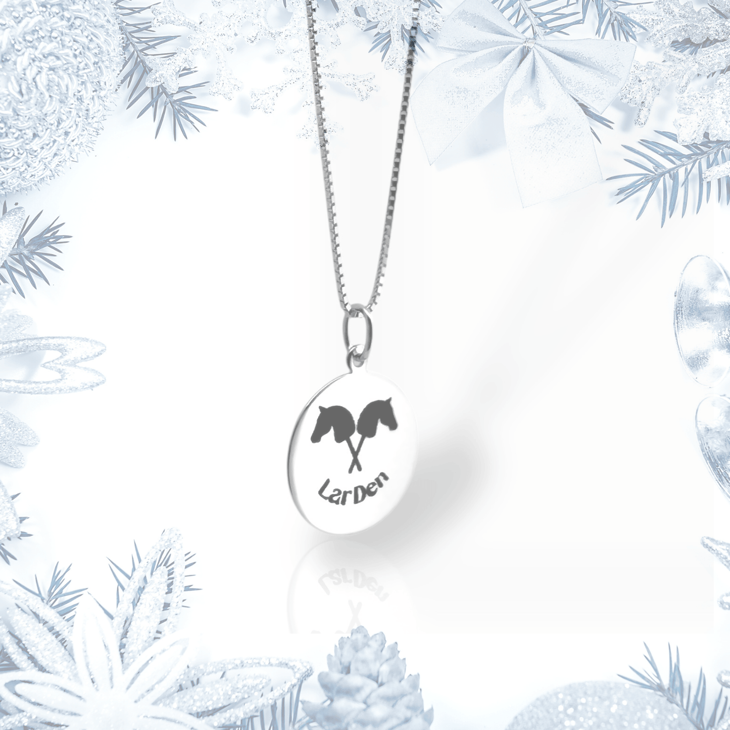 The Hobby Horse LarDen Silver Necklace features a 925 sterling silver oval pendant with two horse heads above "LarDen," celebrating Hobby Horsing and accented by a frosty border of ornaments, ribbons, pine cones, and branches.