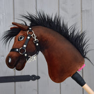 Hobby Horse Benny z czarnym kantarem - rozmiar XS od Hobby Horse LarDen, inspirowany belgijskim koniem gorącokrwistym, z pluszowym brązowym tułowiem, czarną grzywą i kantarem na drewnianym kijku, pokazany na tle jasnoszarych drewnianych paneli.