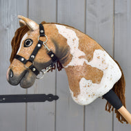 Hobby Horse Biscuit in side view, brown and white plush Hobby Horse with a black halter