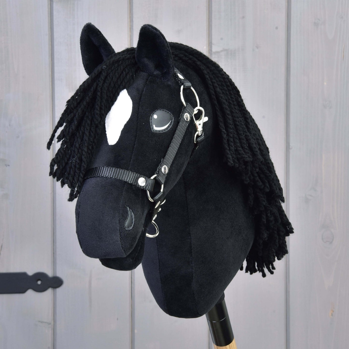 Hobby Horse Cloony with Black Halter featuring soft black fabric and yarn mane on wooden stick for imaginative play.