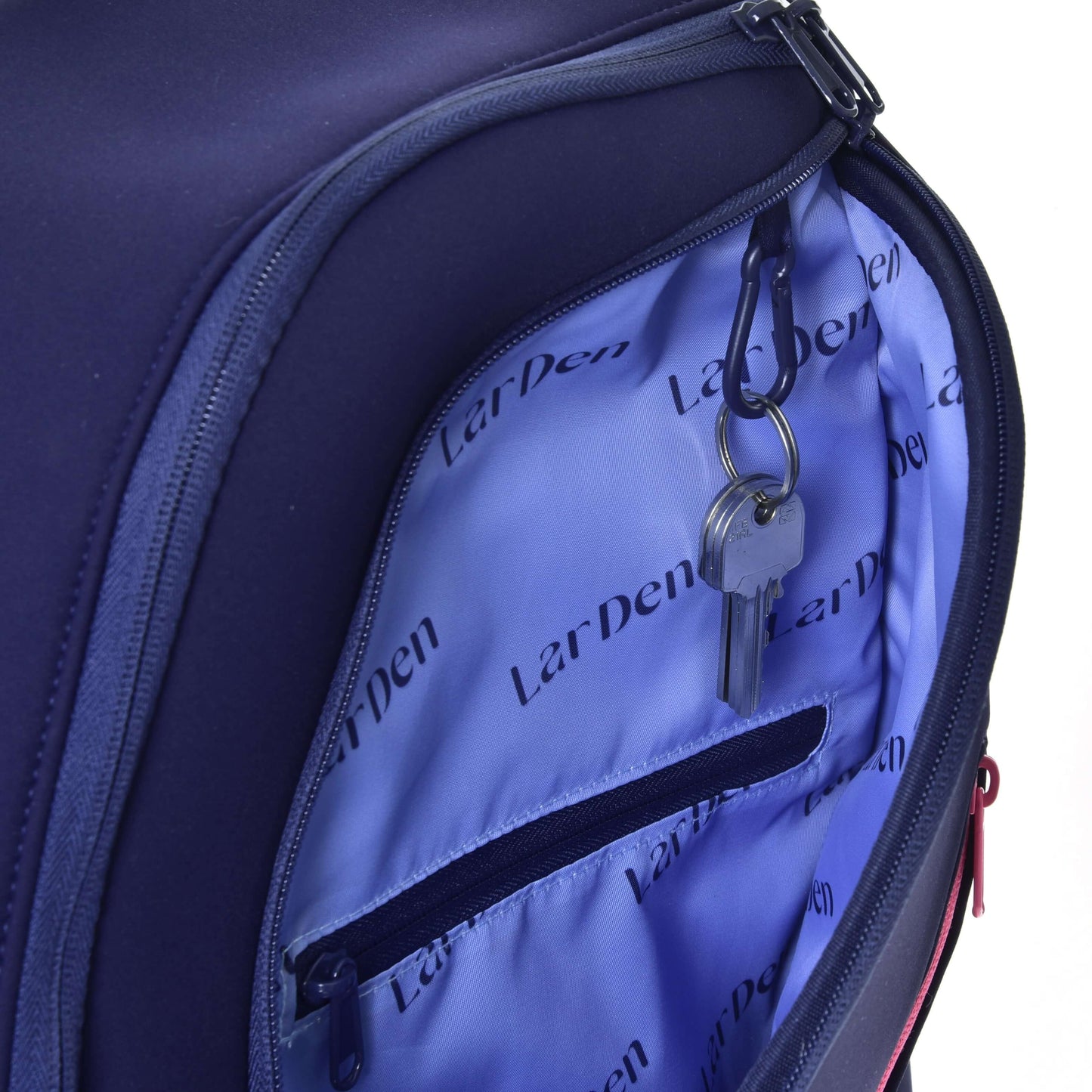 A close-up of an open navy Hobby Horse Backpack LarDen by Hobby Horse LarDen, showing a light blue interior with a zippered pocket, padded straps, and a key holder holding two keys.