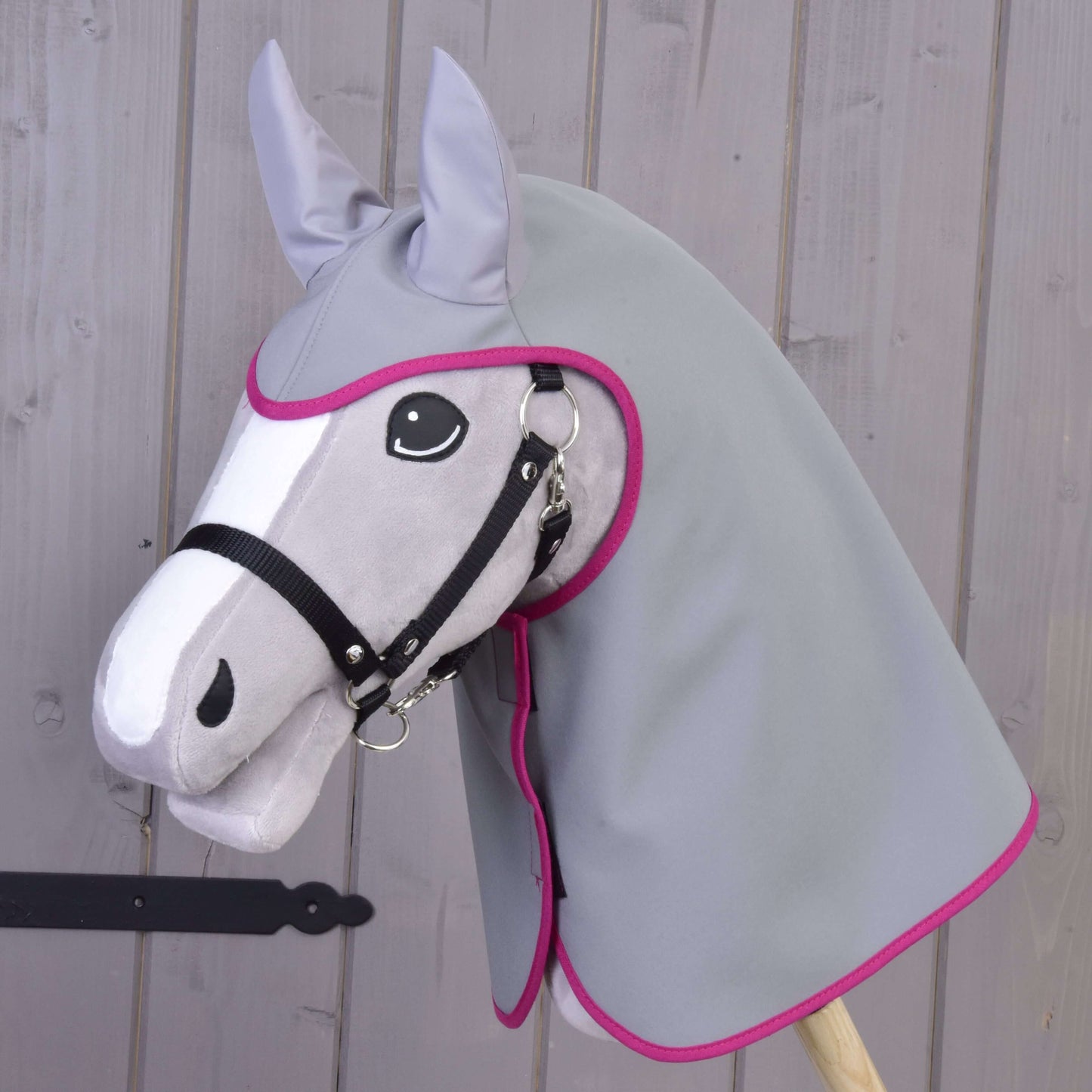 Płaszcz przeciwdeszczowy szary od Hobby Horse LarDen to pluszowy szary Hobby Horse z dopasowanym materiałowym kapturem z różową lamówką i czarnym kantarem, pokazany na drewnianym tle.