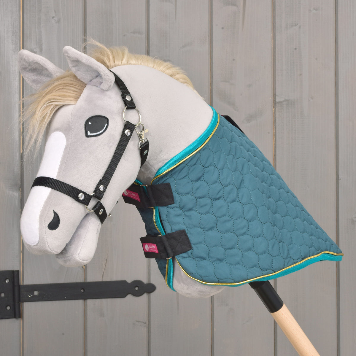 Side view of the green quilted Hobby Horse blanket with turquoise trim and detachable neck cover