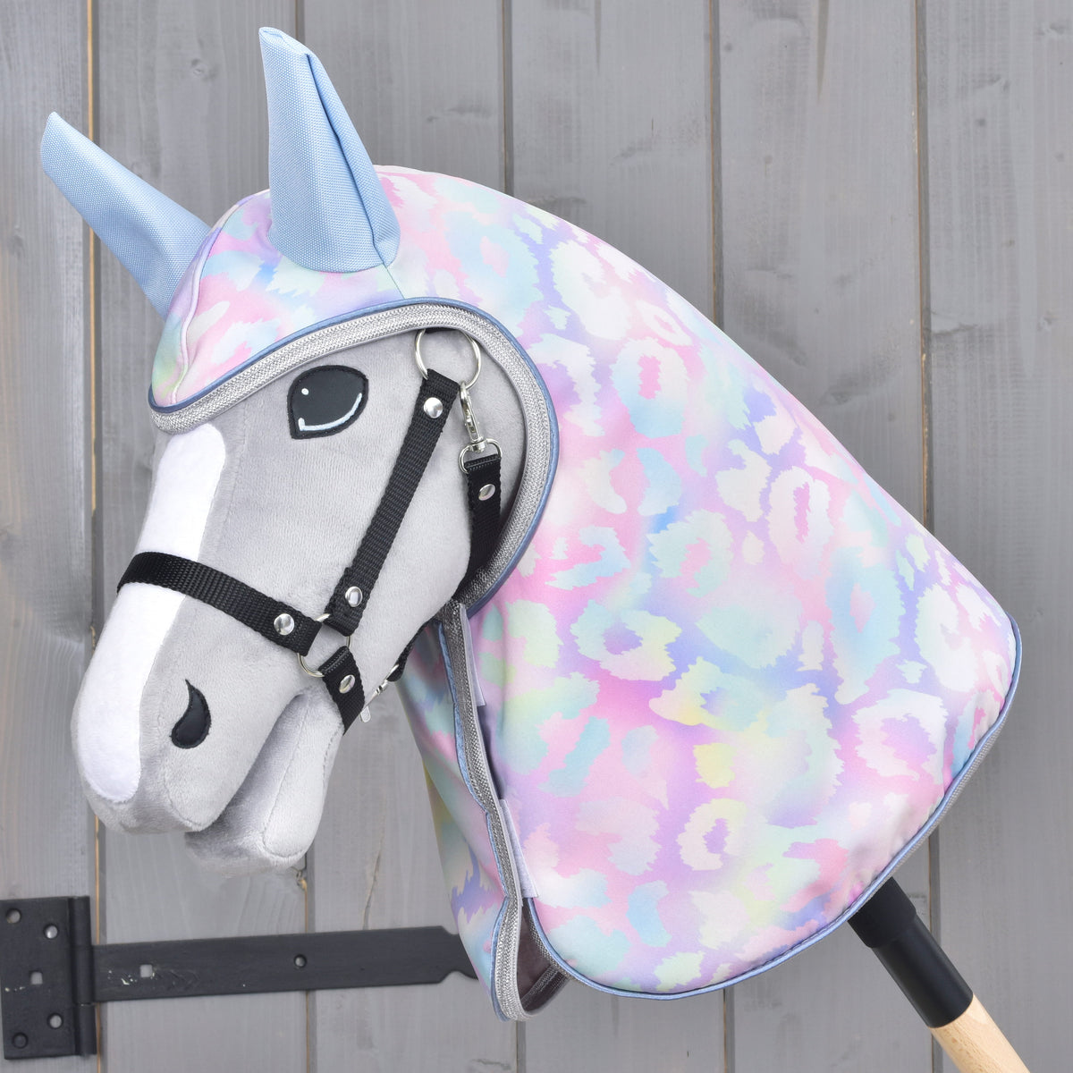 Pastel pink and blue Hobby Horse raincoat worn on a grey Hobby Horse with silver trim