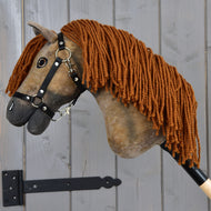 Hobby Horse Rafaello z czarnym kantarem - rozmiar S od Hobby Horse LarDen, brązowy koń hanowerski do Hobby Horse z długą grzywą z włóczki, zamocowany na drewnianej ścianie za pomocą metalowego wspornika.