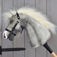 Hobby Horse Silver Moon in side view, with a fluffy white mane and black halter