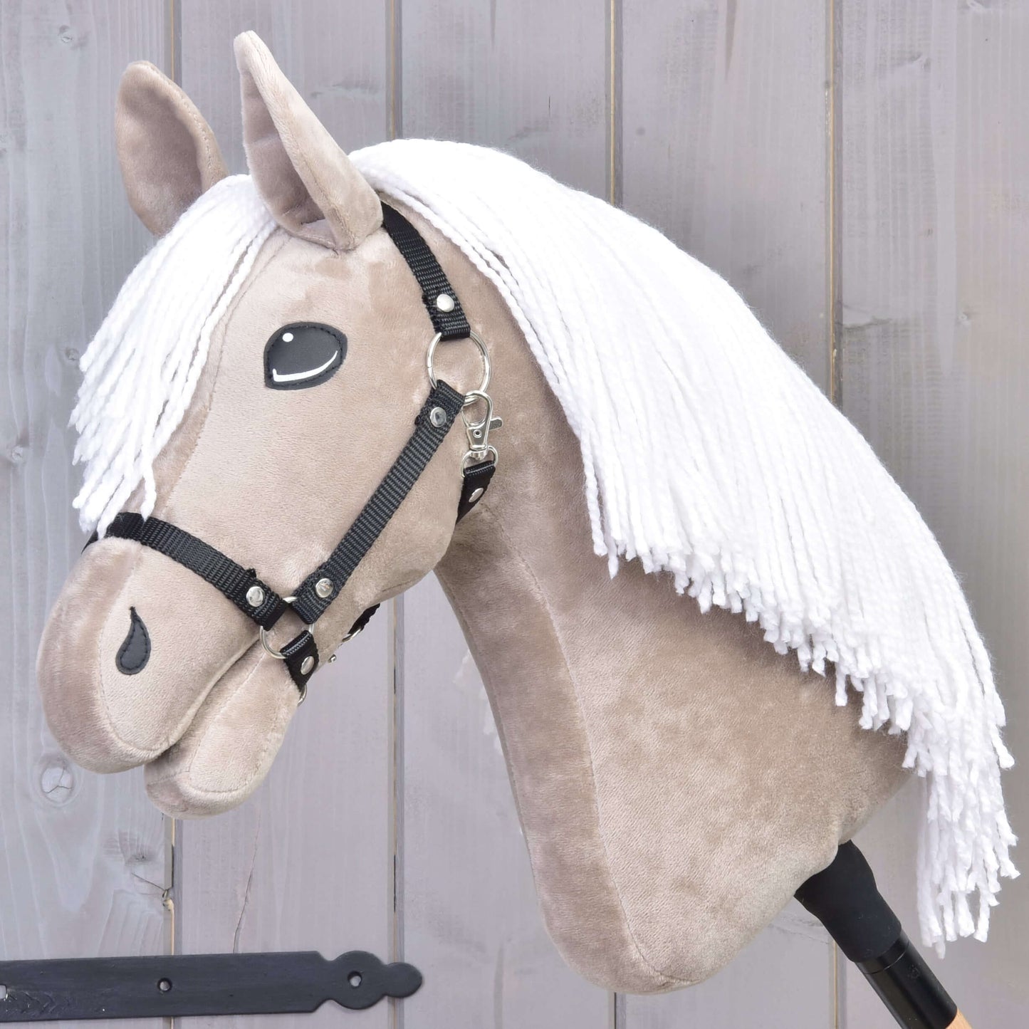 The Hobby Horse LarDen "Hobby Horse Blondie with Black Halter" features a beige face, white yarn mane, and black halter on a wooden stick, displayed against a light gray wooden background.