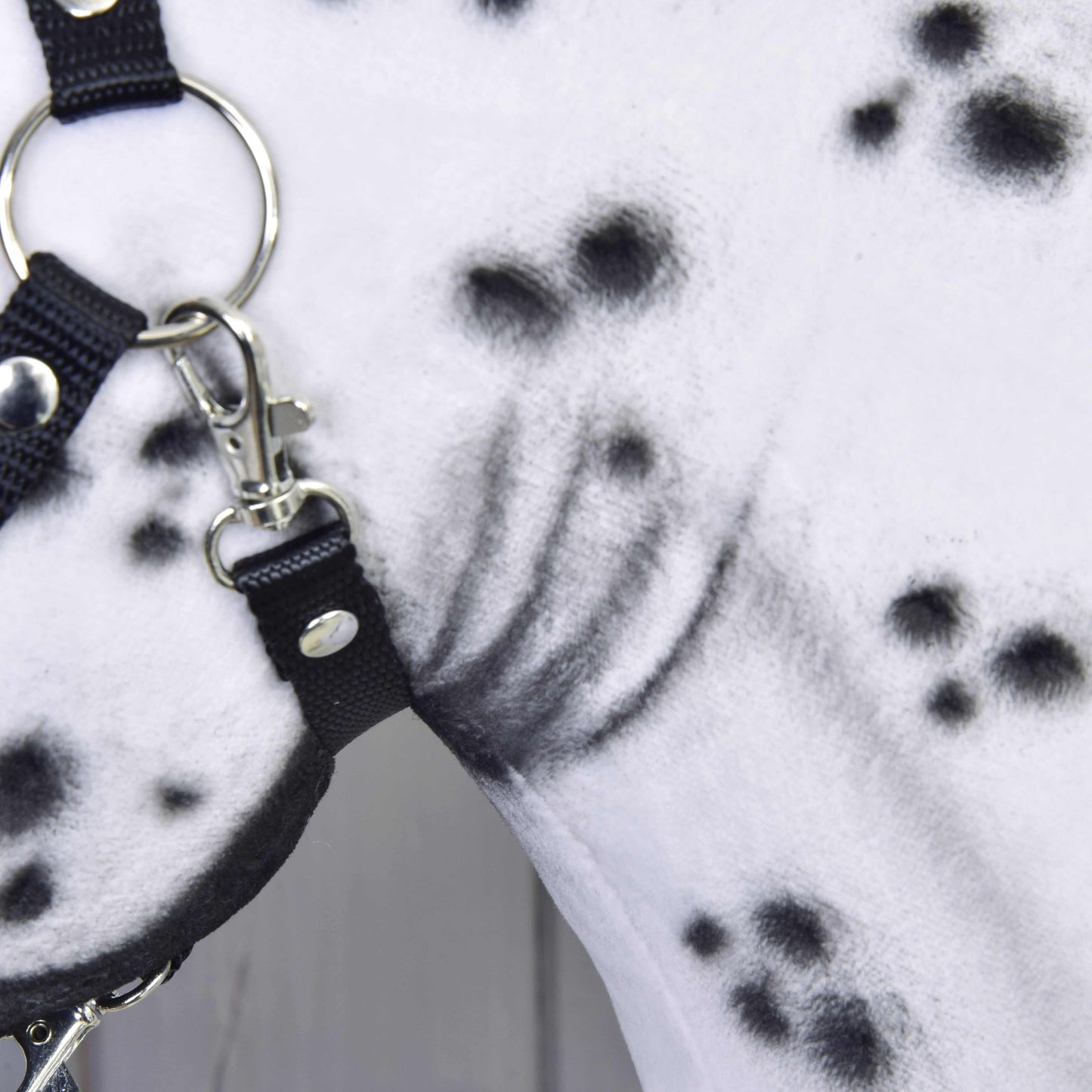 Close-up of the Hobby Horse Chantal by LarDen, featuring a white neck with black spots and a black halter with silver rings and buckles. The unique hand-crafted fur pattern highlights this stunning mare.