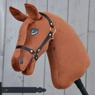 Zbuduj swojego konia od related_to_12441055625556: spersonalizowany Hobby Horse z pluszową głową w ciemnym kasztanowobrązowym kolorze, ozdobioną czarnym kantarem i efektowną brązowo-białą grzywą, osadzony na kiju na tle szarego drewnianego tła.