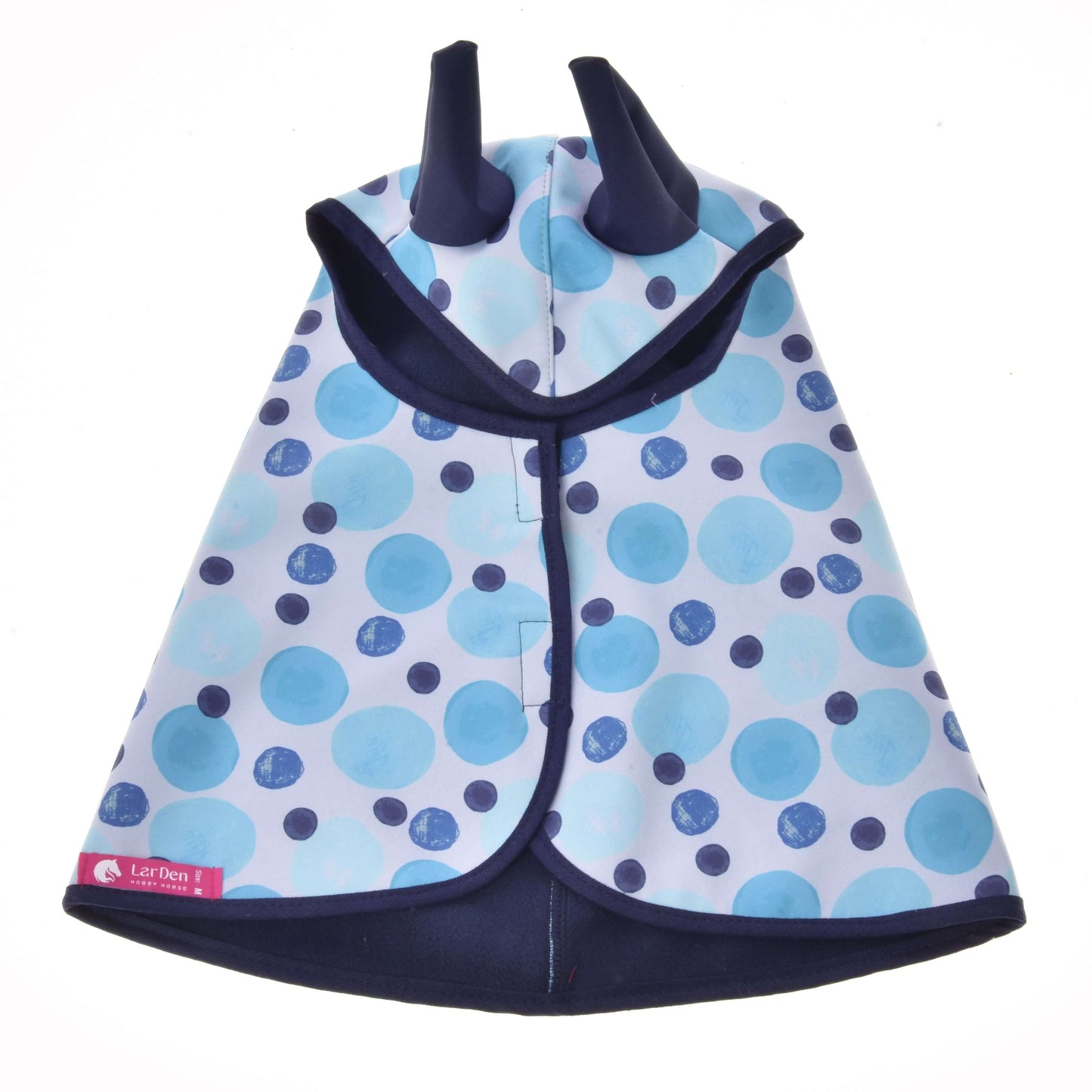 The Raincoat Bubbles by Hobby Horse LarDen is a blue and navy polka dot children’s cape with a hood that has two pointy ears, a pink label near the hem, and is displayed on a white background.